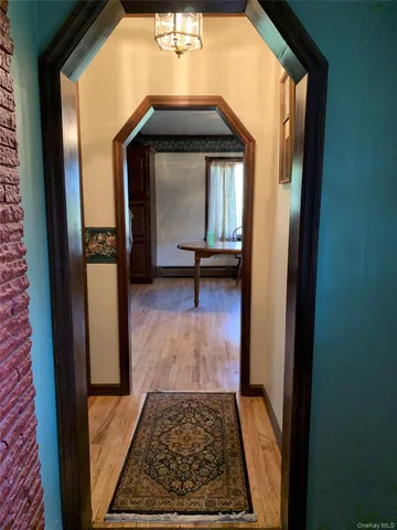 a view of a hallway with wooden floor and furniture