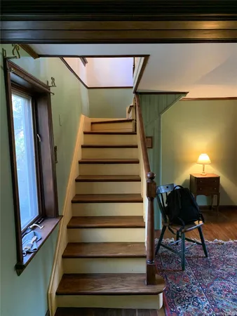 a view of a hallway with wooden floor and furniture