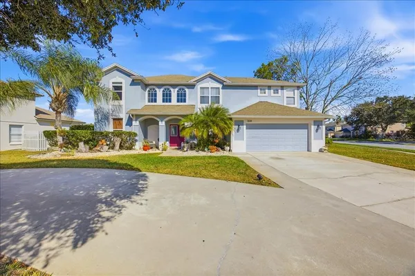 a view of a house with a big yard and large trees