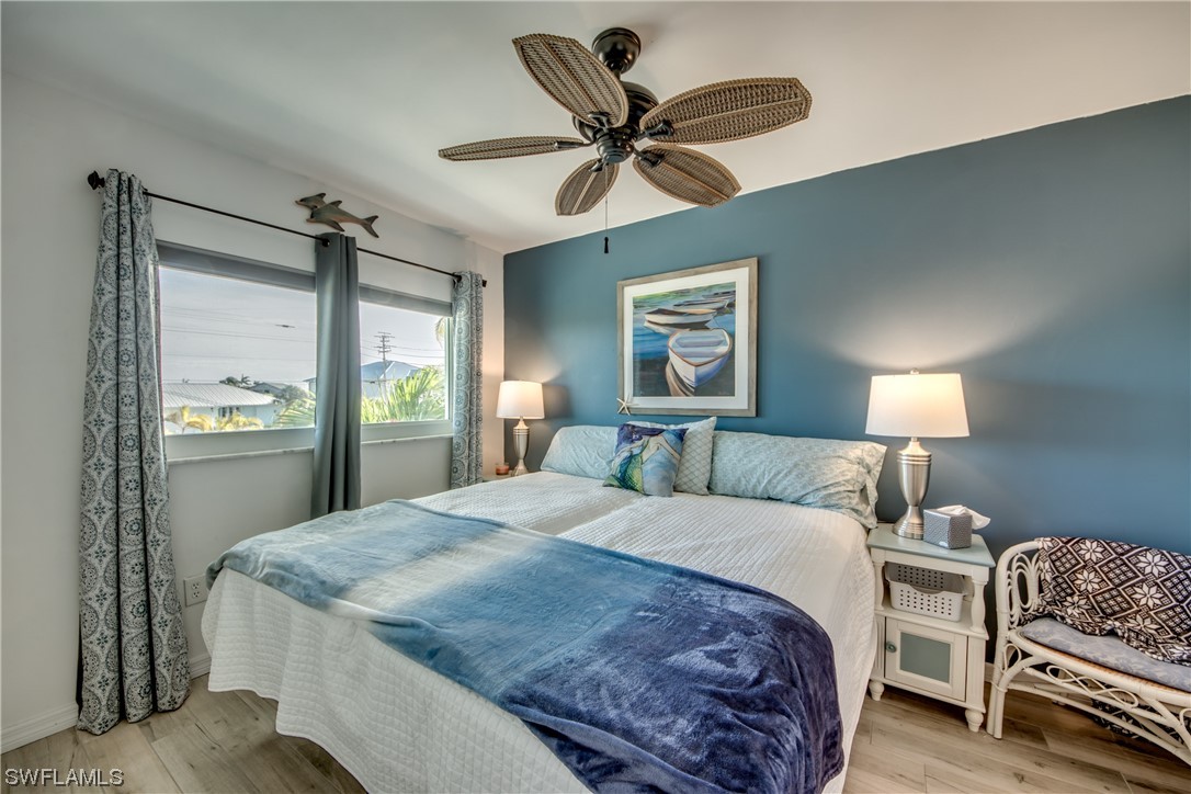 3215 Stringfellow Road, Unit 2D St. James City, FL 33956 - Photo 15 of 39 a bedroom with a bed and a chandelier