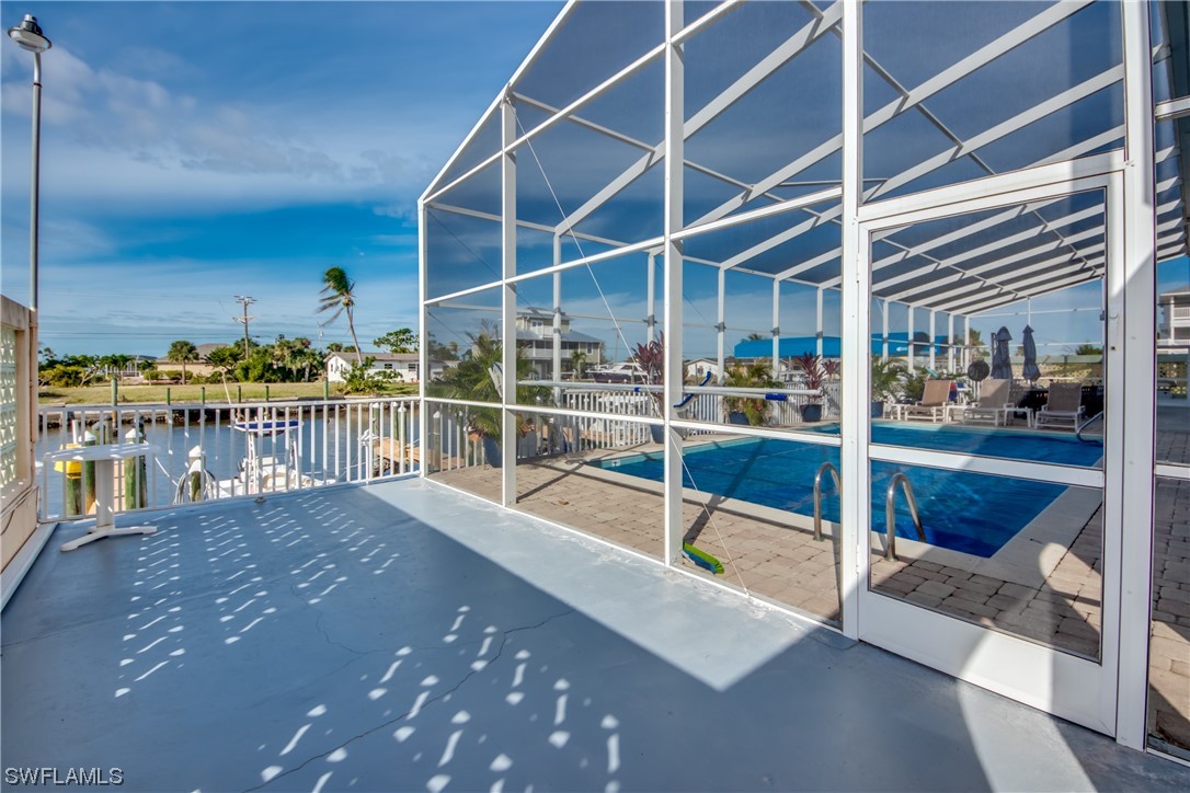 3215 Stringfellow Road, Unit 2D St. James City, FL 33956 - Photo 32 of 39 a view of balcony with two large trees and wooden fence