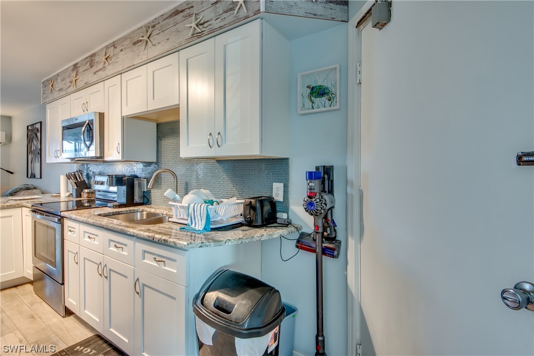 3215 Stringfellow Road, Unit 2D St. James City, FL 33956 - Photo 5 of 39 a kitchen with stainless steel appliances granite countertop a sink stove and cabinets