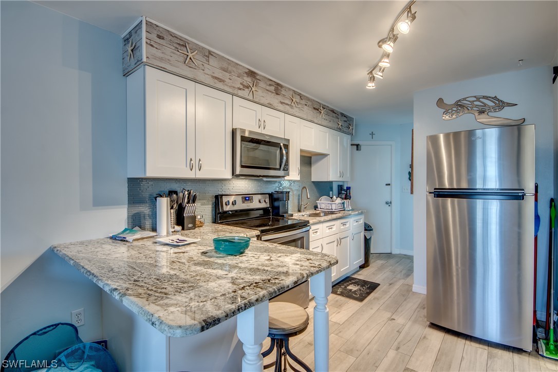 3215 Stringfellow Road, Unit 2D St. James City, FL 33956 - Photo 6 of 39 a kitchen with granite countertop a refrigerator stove and sink