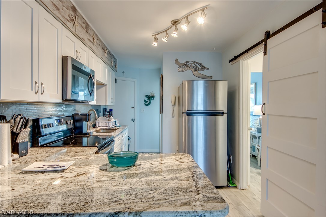 3215 Stringfellow Road, Unit 2D St. James City, FL 33956 - Photo 7 of 39 a kitchen with refrigerator and window