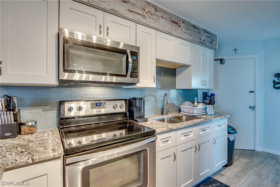 3215 Stringfellow Road, Unit 2D St. James City, FL 33956 - Photo 8 of 39 a kitchen with stainless steel appliances granite countertop a stove microwave and sink