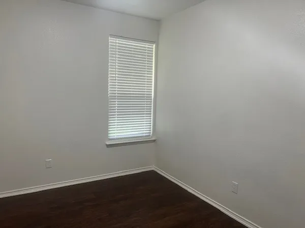 an empty room with wooden floor and a window