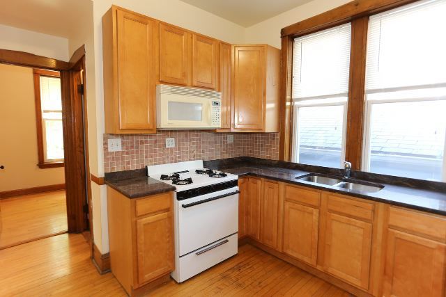 2312 West Iowa Street, Unit 1R Chicago, IL 60622 - Photo 3 of 20 a kitchen with stainless steel appliances granite countertop white cabinets a stove a sink and a microwave