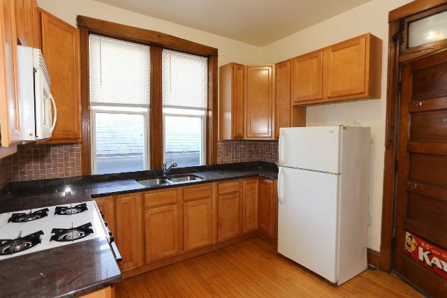 2312 West Iowa Street, Unit 1R Chicago, IL 60622 - Photo 4 of 20 a kitchen with a refrigerator a stove and wooden cabinets