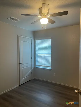 an empty room with wooden floor and window