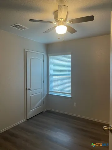 an empty room with wooden floor and window