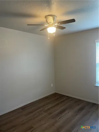 a view of a room with wooden floor and fan