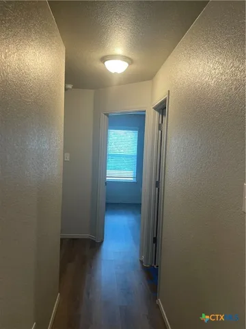 an empty room with wooden floor and a window