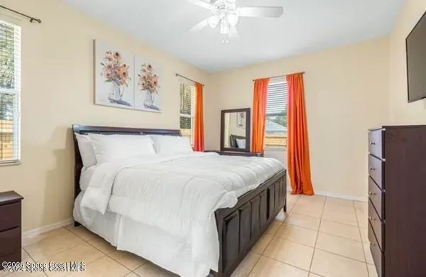 a spacious bedroom with a bed and a chandelier