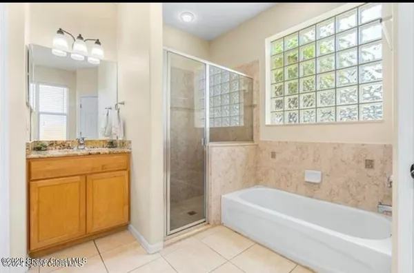 a bathroom with a granite countertop sink a mirror and a bathtub