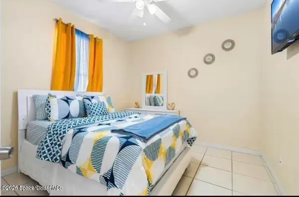 a bed sitting in a bedroom next to a window