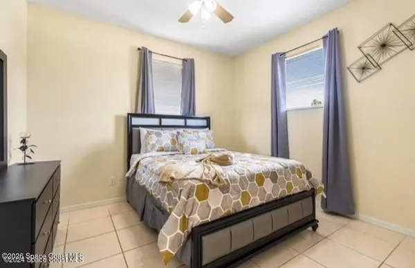 a bed sitting in a bedroom next to a window