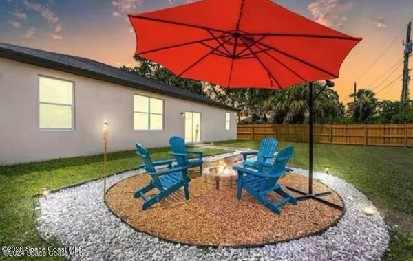 a view of a house with backyard sitting area and furniture