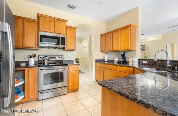 a kitchen with stainless steel appliances granite countertop a sink stove and microwave