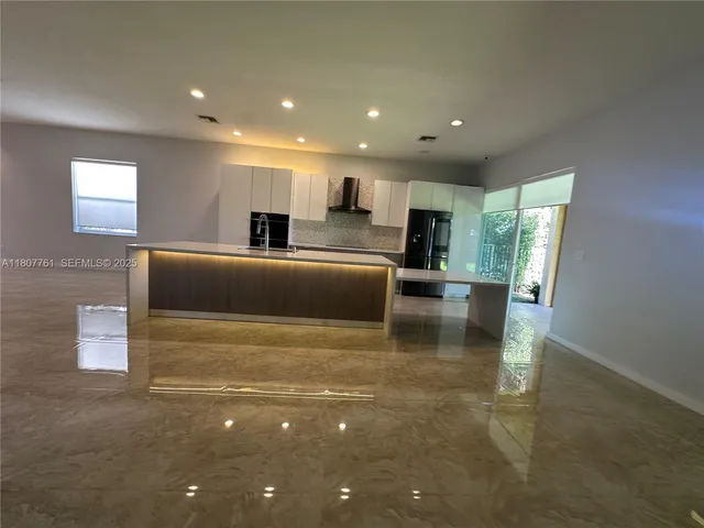 a front view of a house with lots of green space and garden