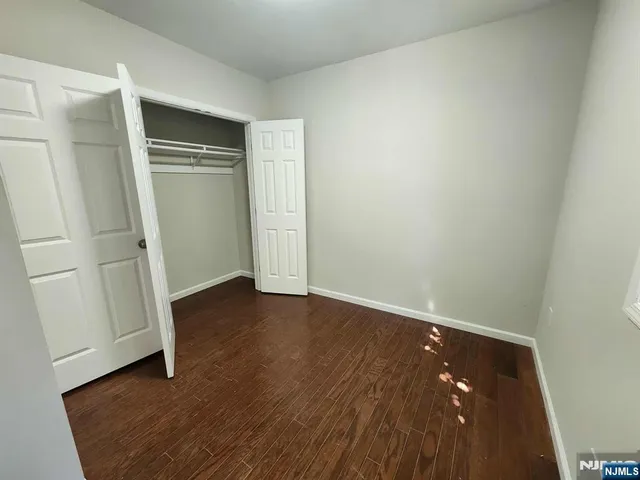 an empty room with wooden floor and closet