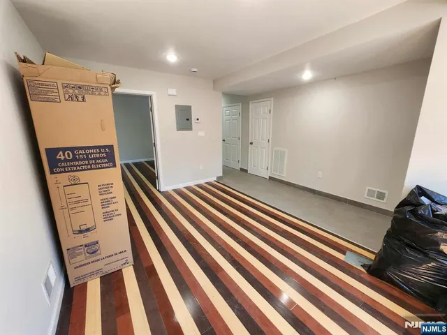 a view of an empty room with wooden floor