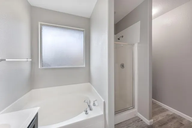 a white bath tub sitting next to a shower