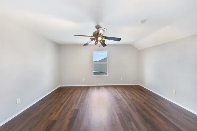 a view of room with window ceiling fan and hardwood floor