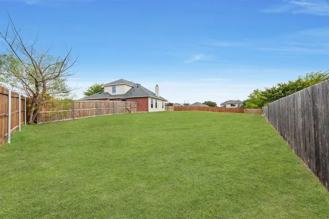 a view of a green field with wooden fence