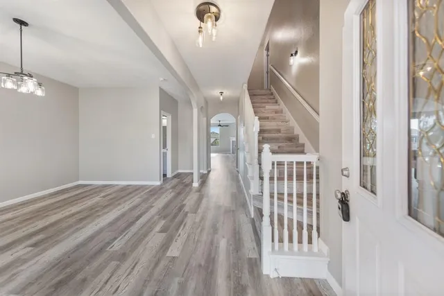 a view of a hallway with wooden floor and stairs