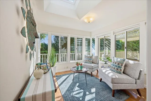 a living room with furniture and a large window with garden view