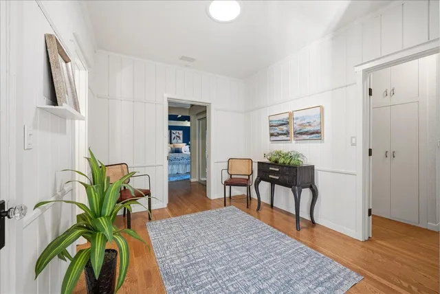 a living room with furniture floor to ceiling window and wooden floor