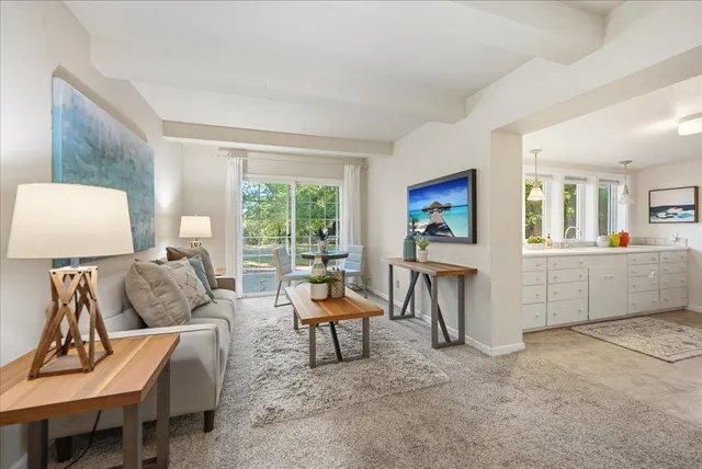 a living room with furniture a window and a flat screen tv