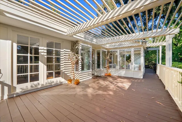 a view of front door with deck and floor to ceiling window