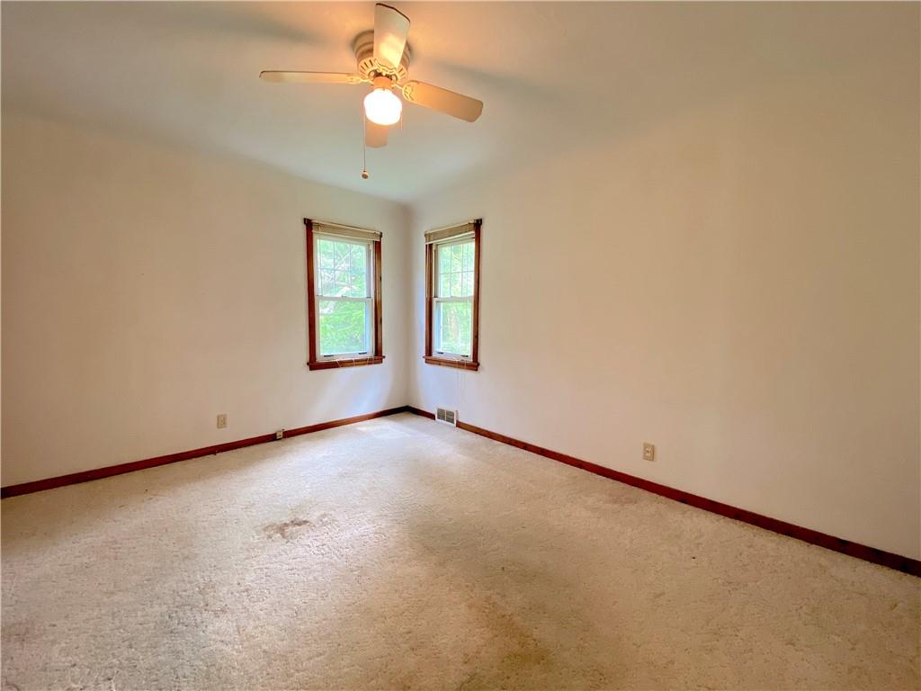 250 Spring Valley Road Jeannette, PA 15644 - Photo 15 of 16 an empty room with a chandelier fan and windows