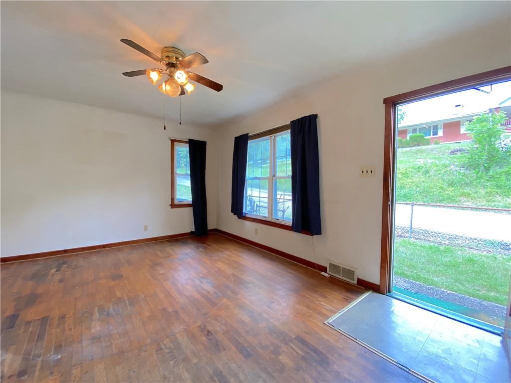 250 Spring Valley Road Jeannette, PA 15644 - Photo 10 of 16 a view of an empty room with wooden floor and a window