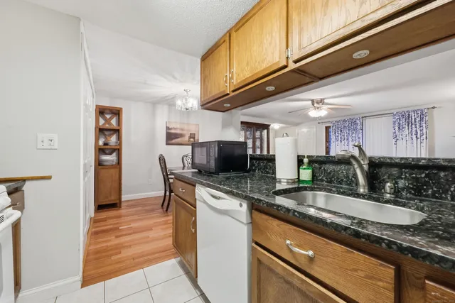 a kitchen with granite countertop a sink and a refrigerator