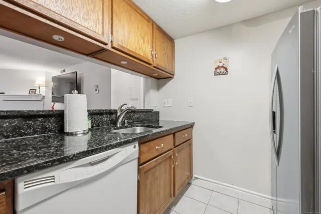 a kitchen with stainless steel appliances granite countertop a sink a stove and a refrigerator