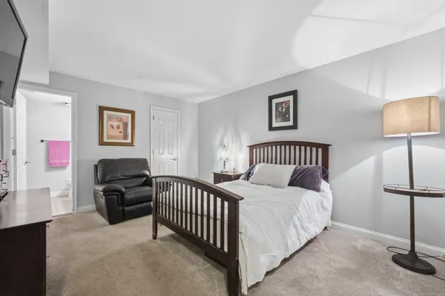 a bedroom with a bed and a lamp with the dresser