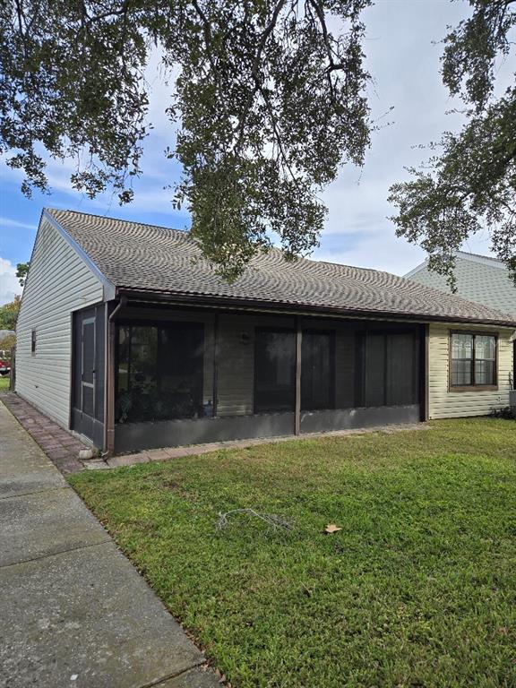 156 Devon Court Dunedin, FL 34698 - Photo 13 of 21 a front view of a house with a yard and garage