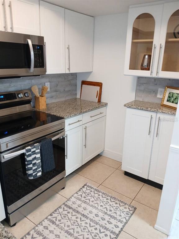 156 Devon Court Dunedin, FL 34698 - Photo 14 of 21 a kitchen with stainless steel appliances granite countertop a stove a microwave and a sink