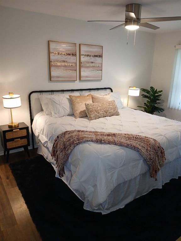 156 Devon Court Dunedin, FL 34698 - Photo 15 of 21 a bed sitting in a bedroom next to a lamp