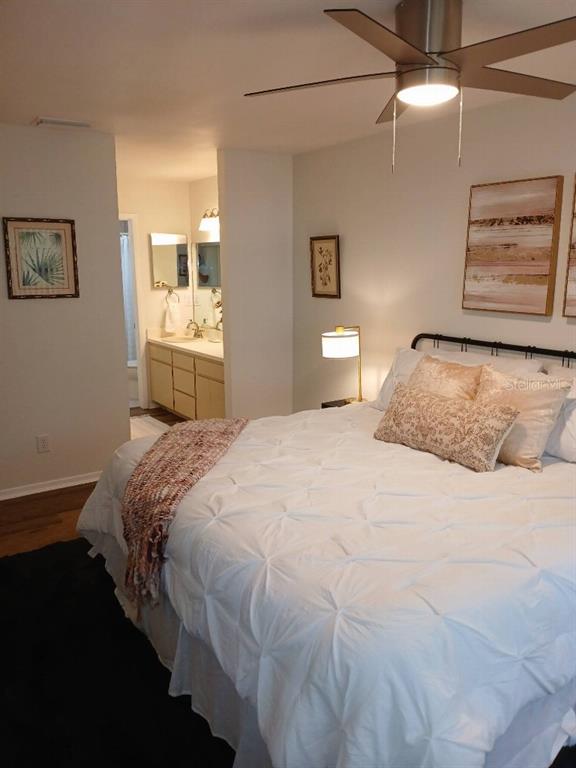 156 Devon Court Dunedin, FL 34698 - Photo 17 of 21 a bedroom with a bed and painting on the wall