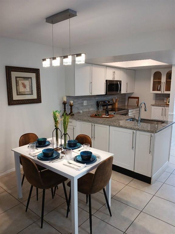 156 Devon Court Dunedin, FL 34698 - Photo 2 of 21 a kitchen with a dining table and chairs
