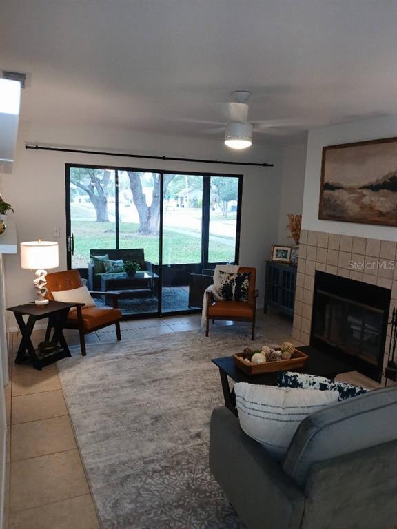 156 Devon Court Dunedin, FL 34698 - Photo 5 of 21 a living room with furniture a fireplace and a flat screen tv