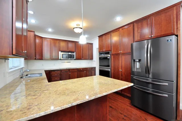 a kitchen with stainless steel appliances wooden floor sink microwave and stove