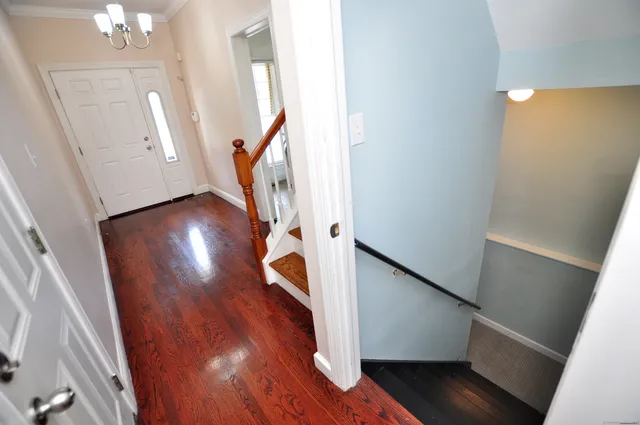 a view of a hallway with wooden floor and staircase