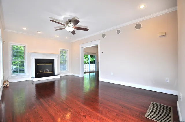 a view of an empty room with window and wooden floor