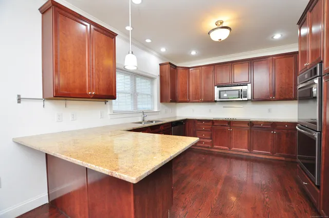 a kitchen with wooden floors and wooden cabinets