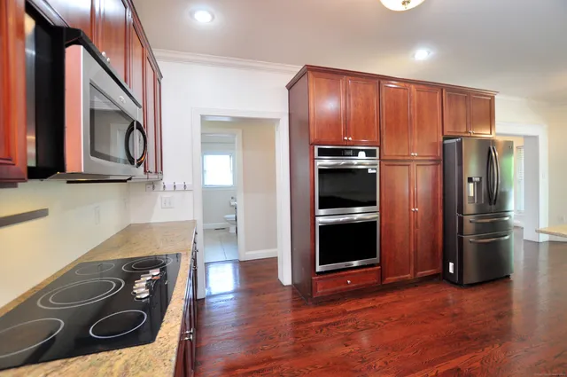 a modern kitchen with stainless steel appliances granite countertop a refrigerator and a stove