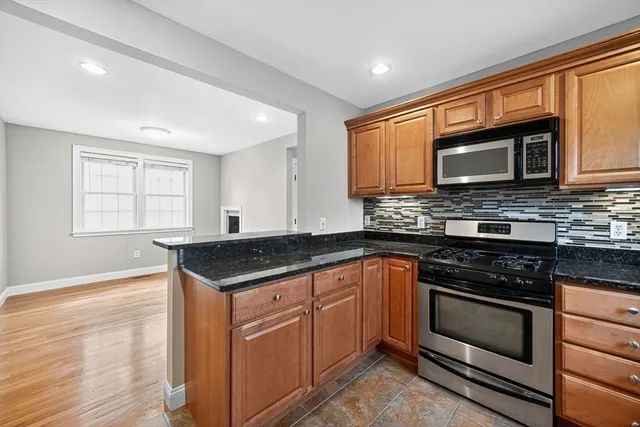 a kitchen with granite countertop a stove cabinets and microwave